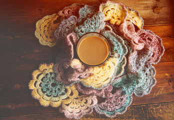 Hot chocolate in mug with marshmallows, wrapped in a woollen scarf