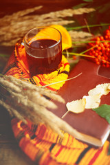 green circle in the scarf, the window with maple leaves and drops after rain in autumn / season when you need warm drinks