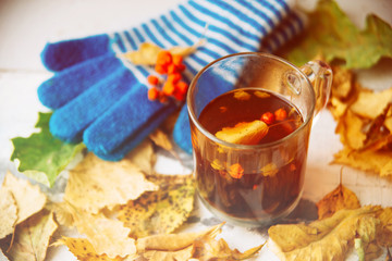 green circle in the scarf, the window with maple leaves and drops after rain in autumn / season when you need warm drinks