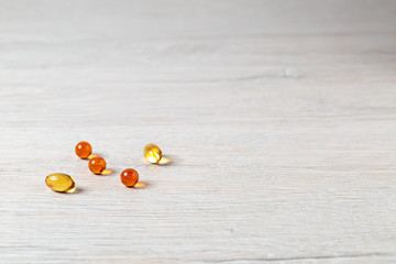 Various fish oil pills capsules on bright table