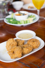 Deep-fried shrimp cakes, served on white dish and served with sweet plum sauce, Thai style appetizers, delicious Thai food.