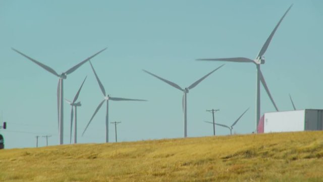 Semi Truck Passes Wind Farm. Diesel fuel semi truck drives past a wind farm on US Interstate 40 in Texas.