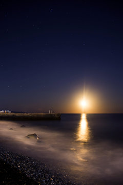 the moon in the starry sky by the sea and the moonlit path