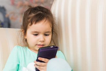 Cute little girl using modern smartphone