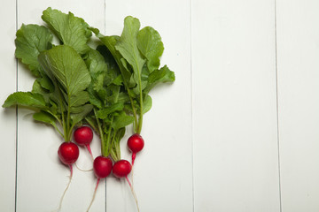 Radishes on a white wooden background