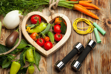 Fresh vegetables, sports, diet on a wooden background