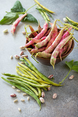 Assorted pod of beans and beans. Red and green beans on a gray slate or stone background.