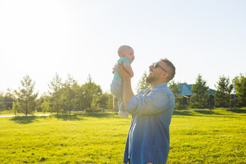 Happy father holding baby son, throwing baby in air. Concept of happy family, father's day and child.