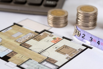 Measure and coins on architectural drawings of the modern apartment. Financing and planning a new house.