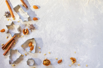Ingredients for Christmas baking - spices, powdered sugar and cookie shapes on a stone background. Seasonal, food background.