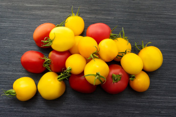 Fresh red and yellow tomatoes close up on wooden table. Top view