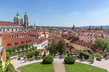 Fototapeta premium View of the Vrtba Garden (Vrtbovská zahrada), St. Nicholas Church and other old buildings at the Mala Strana District (Lesser Town) in Prague, Czech Republic on a sunny day.