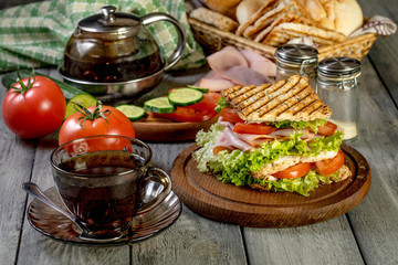 Sandwich with ham, cucumber, tomato and lettuce.