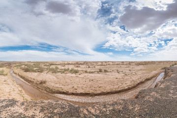 Dry river at center of safari at sunny day with cloudy sky on background