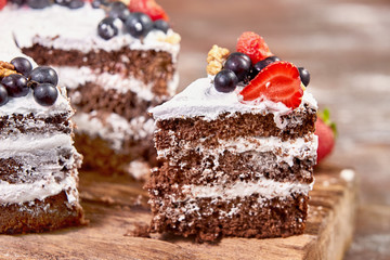 a cut of cake with whipped cream and strawberry fruits on wood table