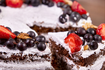 a cut of cake with whipped cream and strawberry fruits on wood table