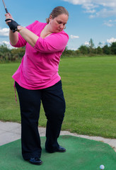 Golfspielerin beim Abschlag auf einem Golfplatz