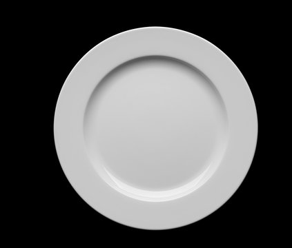 Empty white plate isolated on black background.