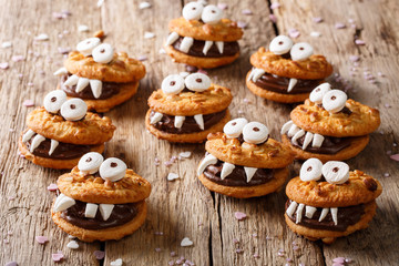 Heloween dessert: funny monsters made of biscuits with chocolate and marshmelow close-up. horizontal