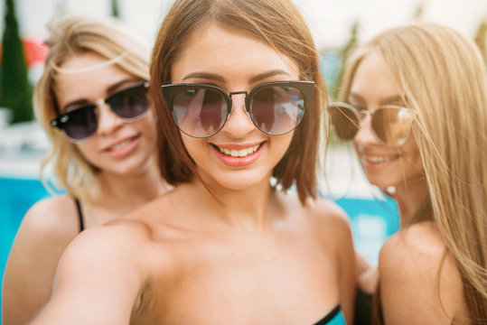 Selfie shot, three happy girls in sunglasses