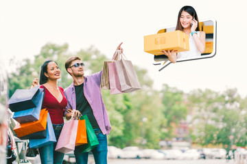Happy Multi-ethnic couple with shopping bag, white man point young small business owner lady, sell goods on mobile phone call. E commerce, shopaholic modern lifestyle, or online shop marketing concept