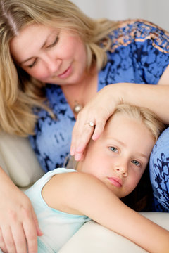Woman hugging a child sitting on the couch