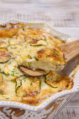 Low carb Green Zucchini casserole with cheese in baking dish