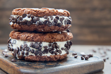 Homemade vanilla ice cream sandwiches with chocolate drops cookies on dark background