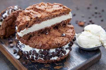 Homemade vanilla ice cream sandwiches with chocolate drops cookies on dark background