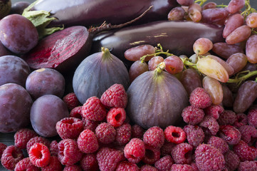 Purple food. Background of berries, fruits and vegetables.  Fresh figs, plums, raspberries, beet, eggplant and grapes