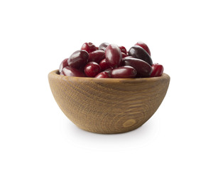 Cornels isolated on a white background. Cornels in a bowl with copy space for text. Ripe cornel close-up.