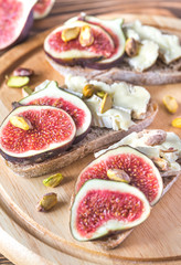 Slices of bread with camembert, figs and pistachios