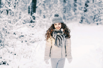 Fototapeta na wymiar Portrait of cute little girl in winter forest. Christmas background.