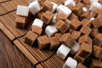 cubes of white and brown sugar on a bamboo napkin