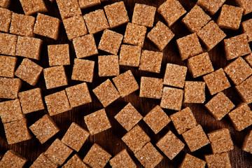 background of cubes of brown sugar on a wooden table