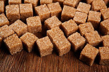 background of cubes of brown sugar on a wooden table