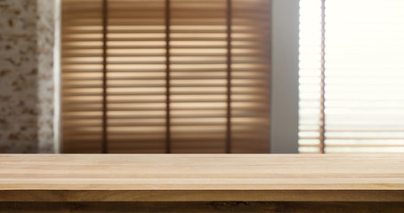 Wood table top with blur window shutters curtain background