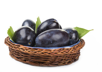 Plums in the wooden basket on the white background