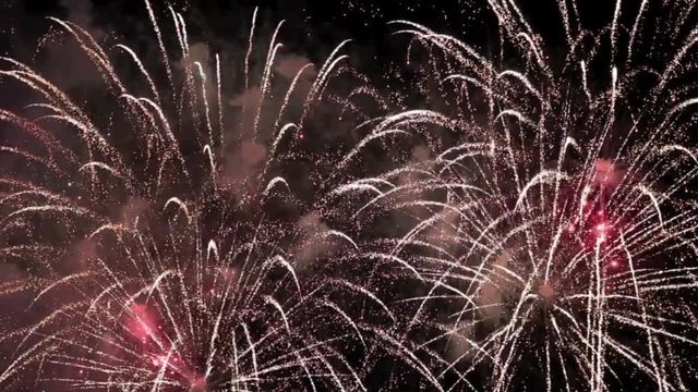 "Happy New Year" als Schriftzug am Ende eines Feuerwerks zum Jahreswechsel mit viel bunter Pyrotechnik