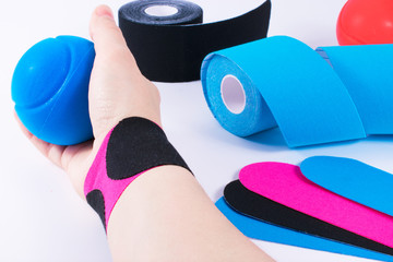 hand with kinesiology tape and stressball. Physiotherapy and therapeutic tape for wrist pain, aches and tension. elastic therapeutic tape. adhesive tape and alternative medicine.