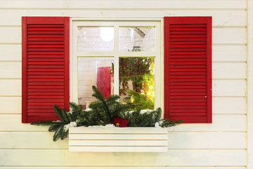 Window with red shutters decorated for Christmas