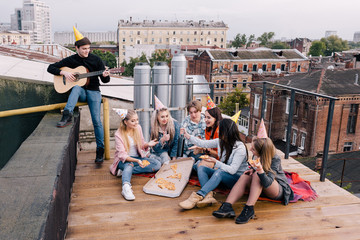 Students birthday party on roof. Leisure time. Music and pizza for young people