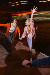 Hectic nightlife. Friendship never sleeps. Run and movement, youth leisure time, blurred background.