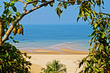 Fototapeta na wymiar View to Paradise beach in Maharashtra from the abandoned fort through the leaves
