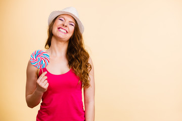 Woman holds colorful lollipop candy in hand