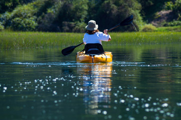 Woman kayaking down river