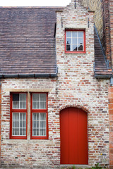Fototapeta na wymiar Red door on old European stone house