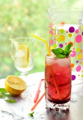 Glass of cold non-alcoholic cocktail with lemon and berry syrup.