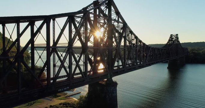 A dramatic rising aerial establishing shot of an old, large railroad bridge over the Ohio River near Monaca, Pennsylvania.  	