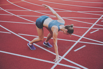 Female athlete in position ready to run. Young woman ready for a sprint.